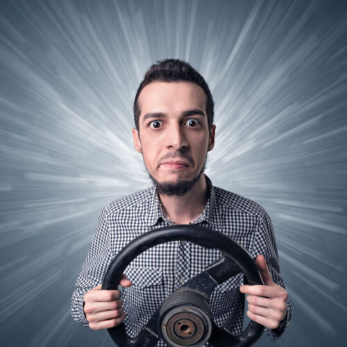 Man holding a steering wheel with a halo of light behind him - cheap car insurance in Washington.