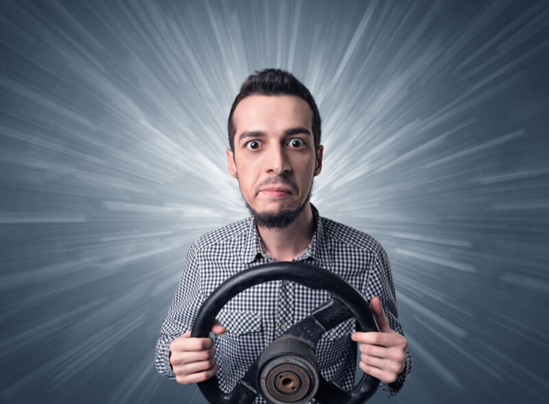 Man holding a steering wheel with a halo of light behind him - cheap car insurance in Washington.