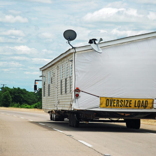 Modular home being transported along interstate highway - Affordable Washington Manufactured Home Insurance